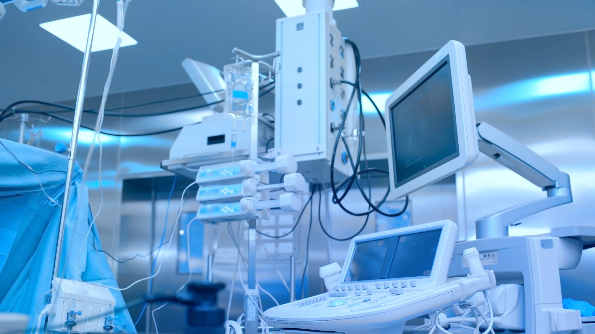 A medical surgery room with various equipment, including surgical trays, diagnostic machines, and surgical instruments.