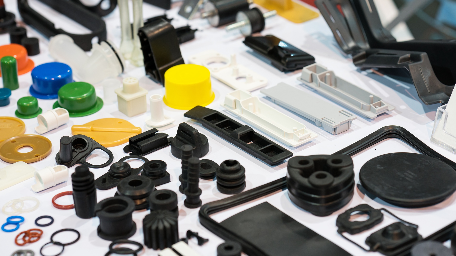 Numerous small plastic parts, including rings, caps, and other components, laid out on a white surface.