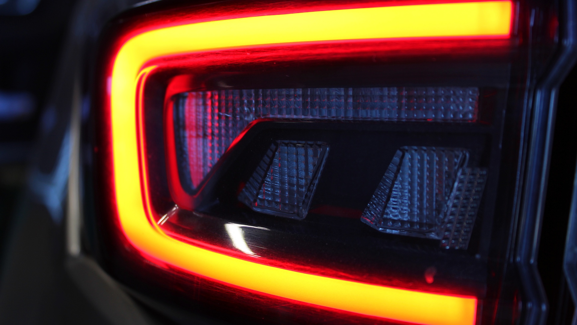A close-up view of a vehicle's glowing orange brake light. The other lighting components are not illuminated.