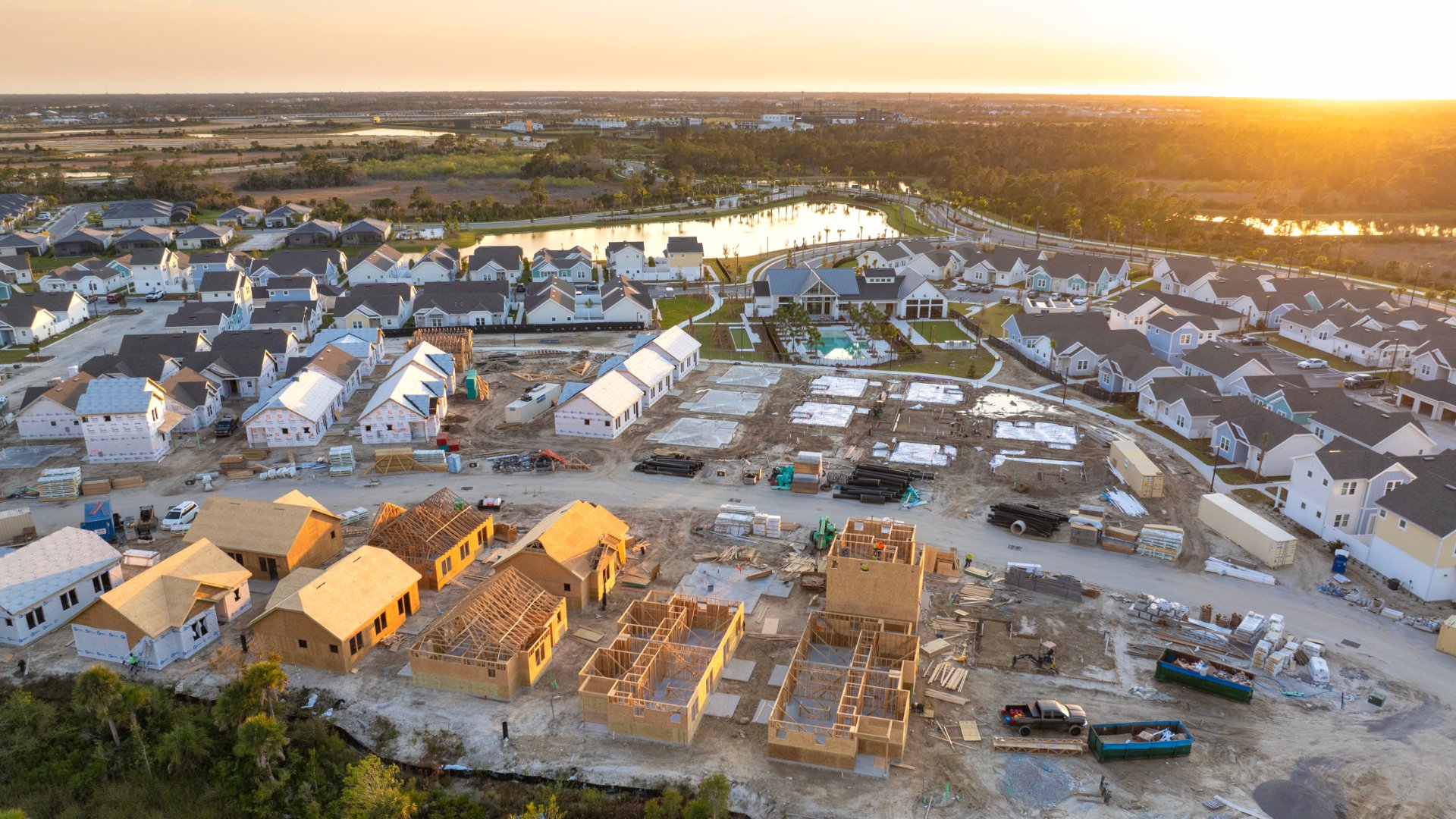 An aerial view of a neighborhood with new development. Several houses are in varying stages of development.
